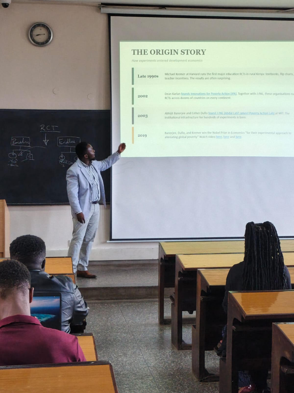 Teaching development economics — walking the class through the origin story of RCTs.